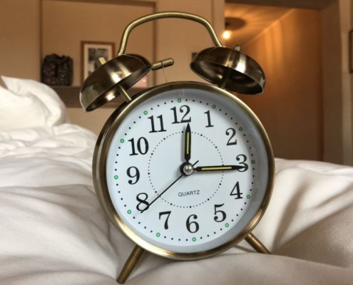 Uhr auf dem Bett wegen Schlafmangel
